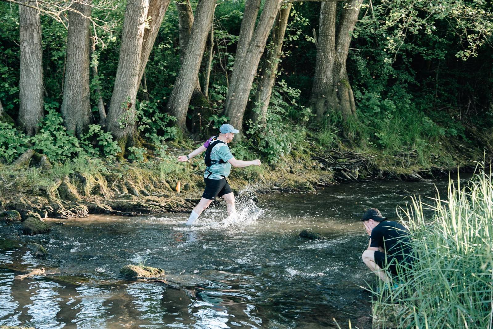 Une coureuse traverse la rivière sous les arbres