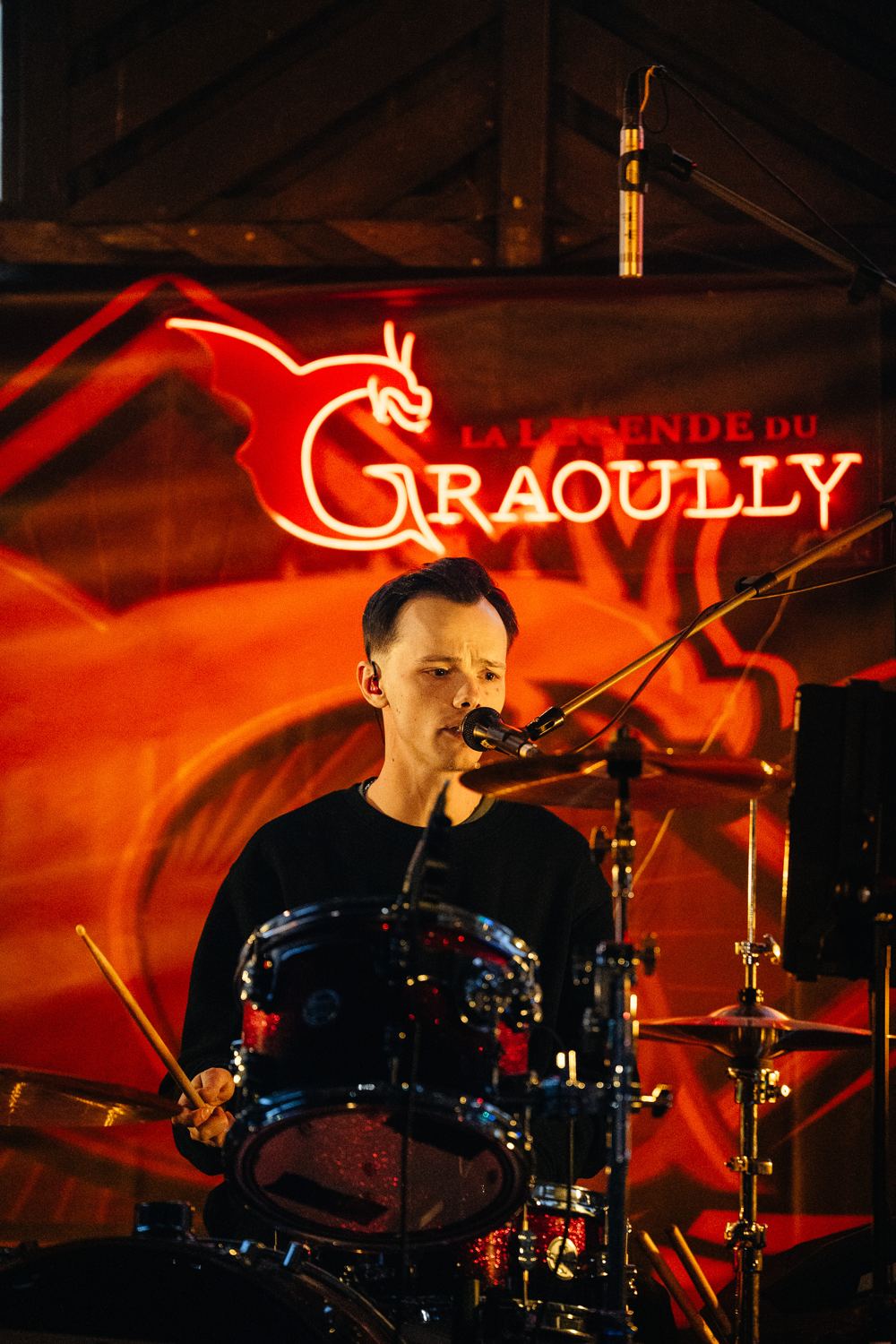 Le batteur devant le néon rouge Graoully